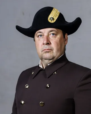 Bereiter der Spanischen Hofreitschule, Jochen Rothleitner, in Uniform vor grauer Wand