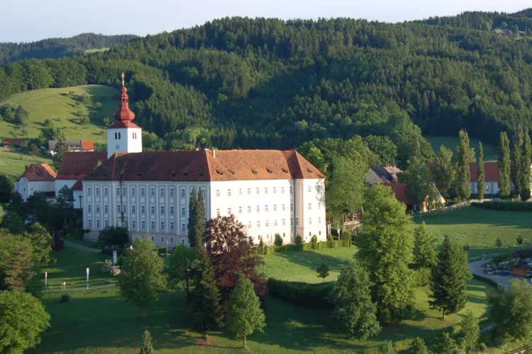 ein Barockschloss in grüner Hügellandschaft