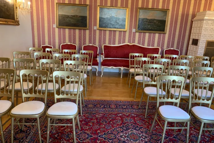 Das Bild zeigt eine Theaterbestuhlung mit goldenen Sesseln und cremefarbigem Polster